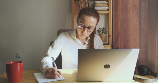 Female Student Glasses Studies Home Front Laptop Writes Notes Notebook — Stok video