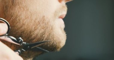 Mans mustache is trimmed with scissors. Close-up, front view, chin and face. Concept of barbershop, hairdresser, mustache care, male beauty, professions. High quality 4k footage