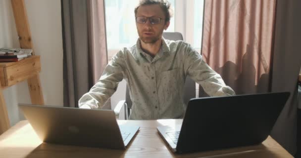 Young Man Working Two Laptops Communicates Video Call Front View — Vídeo de Stock