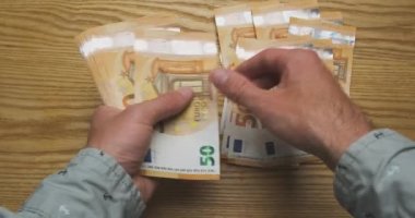 Mens hands count money, cash euro. Top view from the first person. Concept of getting a salary, credit, work, taxes, finance, payment for services, high price. High quality 4k footage