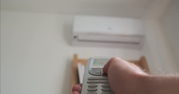 Pov Mans Hand Turns Air Conditioner Using Remote Control Close — Stockvideo