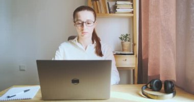 Young woman tired working computer. Tired eyes, takes off his glasses, touches his neck and eyes. Concept burnout work, fatigue, pain in the eyes, neck, overwork. Front view, portrait, workplace
