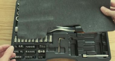 Mans hand opens a set of tools, takes a ratchet socket wrench. Top view, close-up. High quality 4k footage