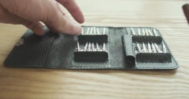 Man opens a set of mini screwdrivers with interchangeable bits in a black leather case. First person view. High quality 4k footage