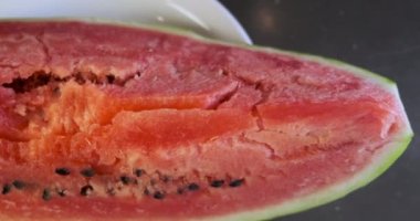 Huge piece of red watermelon lies on a plate. Panorama above the plate, top view, close-up. High quality 4k footage