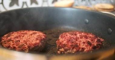 Ready two burger patties in a frying pan. Smoke, close-up, well-roasted beef meat with a crust. Home cooking hamburger. High quality 4k footage