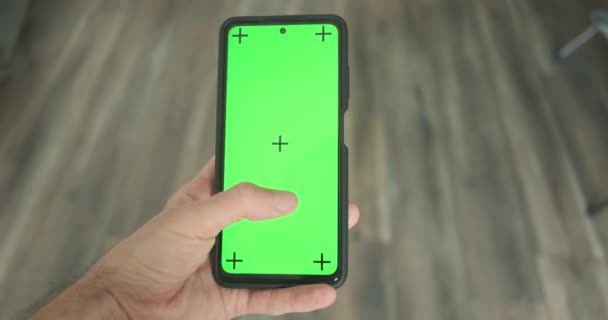 Mans Hand Holds Smartphone Green Screen Vertically Clicks Swipes Close — стоковое видео