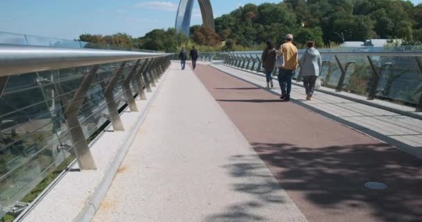 Különböző Felismerhetetlen Emberek Sétálnak Egy Gyaloghídon Üvegkorláttal Visszanézni Kerékpárút Zöld — Stock videók