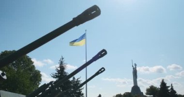 Ukrayna 'nın en büyük bayrağı, rüzgarda sallanıyor. Arka planda top fıçıları ve Anavatan anıtı var. Ukrayna Yüksek kalite 4K görüntü