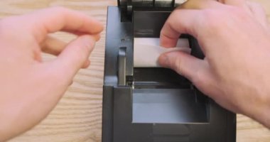 Termal kağıdı bir makbuz yazıcısına yerleştiriyorum. İlk bakışta elleri yazıcıya sokuyor. Yüksek kalite 4k görüntü
