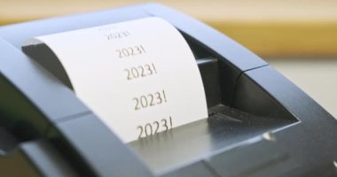 Makbuz yazıcı baskısı metni: 2023. Yakın plan, yan görüş. Tatil kavramı, yeni yıl, noel, yeni sahne, promosyonlar, mağazalarda satış. Çeki yırt at. Yüksek kalite 4k görüntü