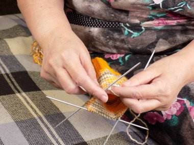 Hand knitting with woolen threads on knitting needles