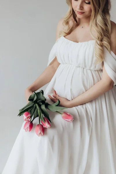 Mulher Grávida Loira Vestido Branco Estúdio Fundo Branco Segurando Buquê — Fotografia de Stock