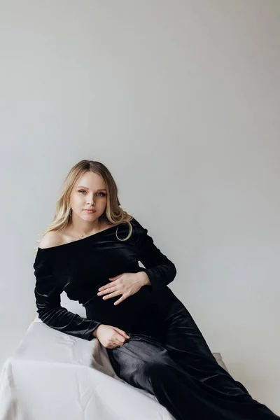 Eine Schwangere Blondine Schwarzem Kleid Liegt Studio Auf Weißem Hintergrund — Stockfoto