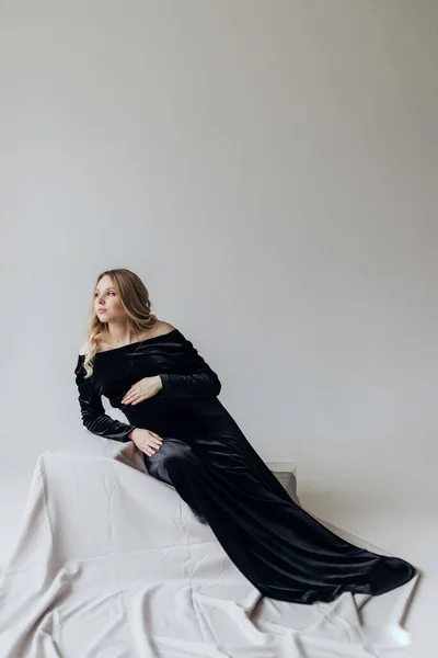Pregnant Woman Blonde Black Dress Lies Studio White Background Holds — Stock Photo, Image