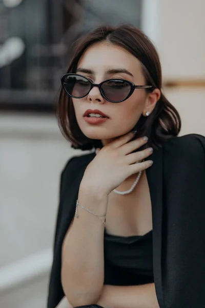 Brunette Girl Black Jacket Dress Black Glasses Sits City Handbag — Zdjęcie stockowe