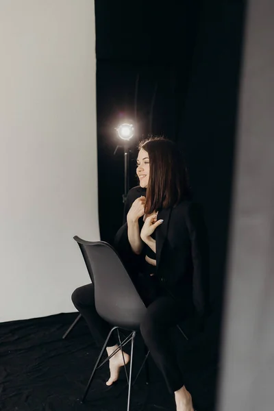 Girl Black Suit Black Background Sits Chair — Fotografia de Stock