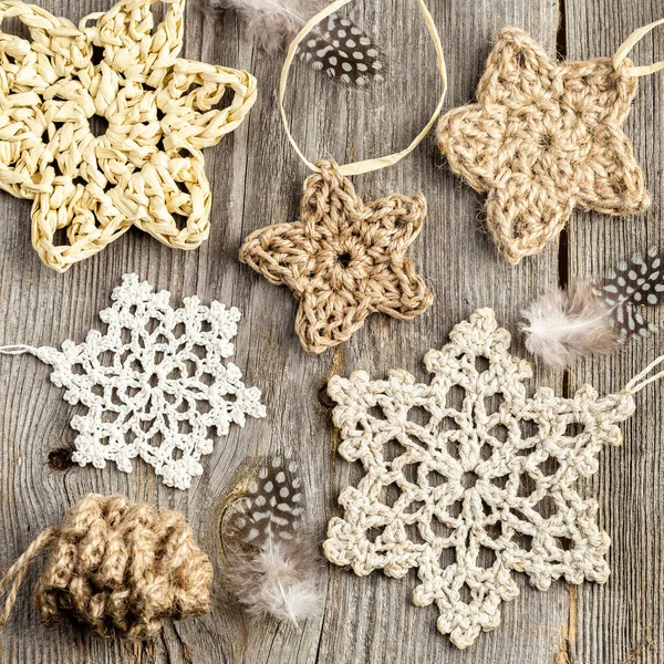 冬やクリスマスの木製の背景には かぎ針編みの星や雪片があります 自然の素材で作られた手作りのクリスマスの装飾 トップビュー フラットレイアウト — ストック写真