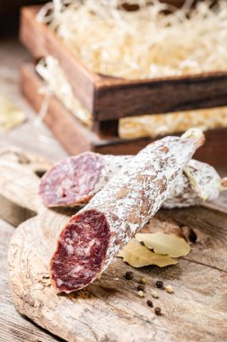 Eski ahşap bir masada tütsülenmiş salam. Yenilebilir küflü sosisler.