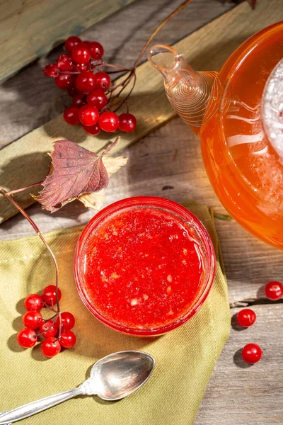 在乡村风格的木制桌子上的玻璃碗里放着维伯纳姆果酱 上面放着冬热饮料和维伯纳姆浆果 — 图库照片