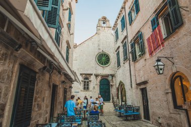 Dubrovnik, Croatia - September 18, 2019: Old narrow street of Dubrownik old city with tourists and open air cafe