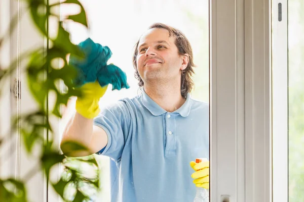 穿着黄色防护手套的男人在家里擦窗户 做家务例行公事 有选择地注重脸部 — 图库照片