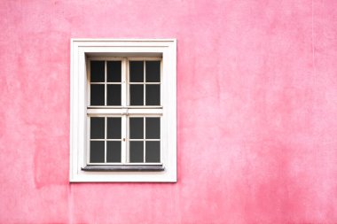 Renaissance style window with white frame on pink wall color. Building exterior. Copy space for design 