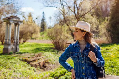Sonbahar parkında Olesko Kalesi 'nin yanından geçen mutlu turist kadın mimariye ve doğaya hayran kalıyor. Manzaralar ve antik ilgi alanları