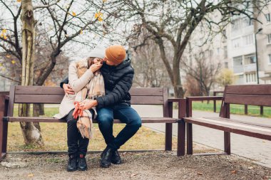 Sevgili koca, karısını destekliyor sonbahar parkında açık havada sarılıyor. Üzgün depresif kadın, ağlayarak yüzünü kapatıyor. Taşıyıcı adam yardım ediyor ve rahatlatıyor.