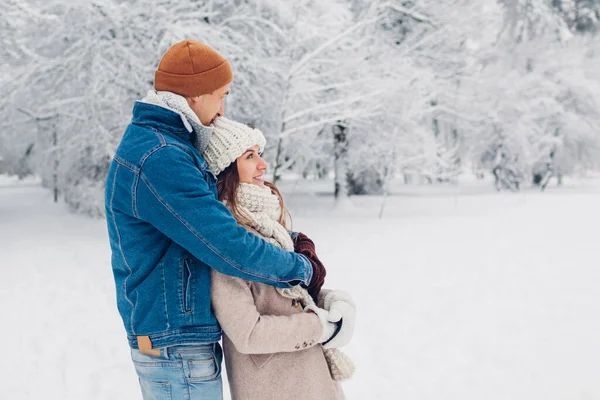 年轻貌美的恋人在冬季公园散步 在户外欣赏雪景的男女拥抱 — 图库照片
