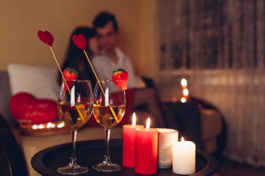 Şenlik şenliklerinin kapanışı çilekli şarap ve kırmızı mumlarla süslenmiş kalp. Sevgililer Günü çifti