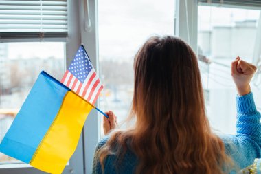 Rusya 'yla savaş sırasında elinde Ukraynalı ve Amerikan bayrakları tutan kadın. ABD yaptırımları destekliyor. Ukrayna 'da istila. 2022 Rusya 'nın Ukrayna saldırısı