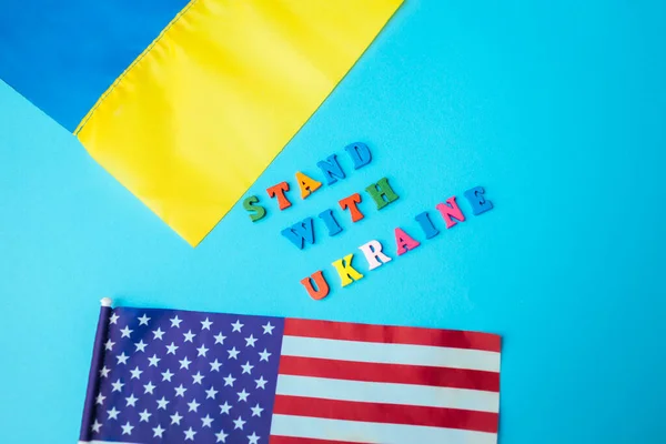 Встань с лозунгом Украины. Украинские и американские флаги во время войны. Вторжение на Украину. Атака России на Украину — стоковое фото