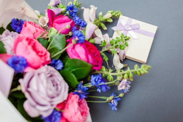 Yaz çiçeğinin buketini kapat tilki eldivenli bekarlığa veda düğmeleri kağıda sarılıp arka planda hediye kutusuyla düzenlensin. Tatil için taze çiçekler.