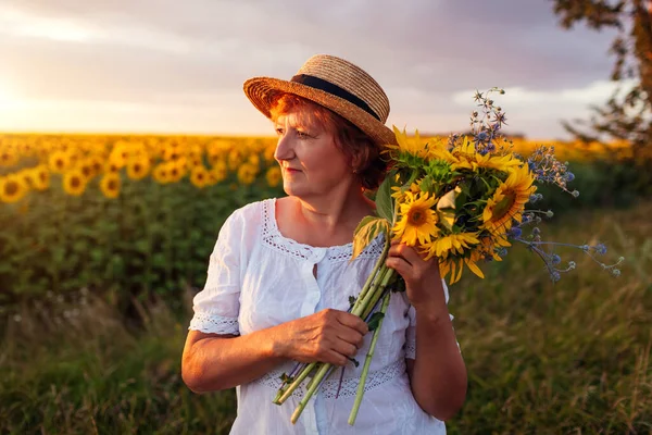 Senior Woman Holds Bouquet Yellow Sunflowers Summer Field Sunset Middle — стоковое фото