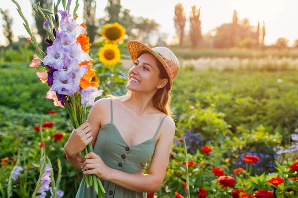 Portret Młodej Ogrodniczki Trzymającej Letnim Ogrodzie Kilka Świeżych Gladioli Szczęśliwy — Zdjęcie stockowe