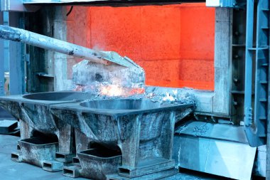 erimiş alüminyum döküm önce cüruf kaldırmak için gözden geçirme. Alüminyum döküm açık bir fırın gösteren çalışır