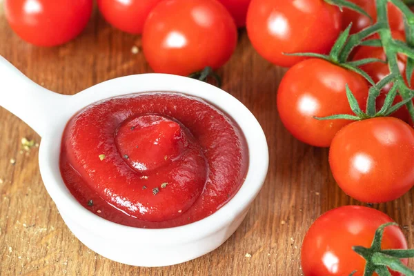 Ketchup in una pentola di salsa bianca, pomodorini su un ramo — Foto Stock
