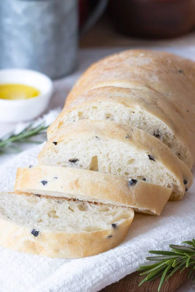 Ciabatta de trigo en rodajas con aceitunas sobre una toalla blanca. Pan casero de trigo — Foto de Stock