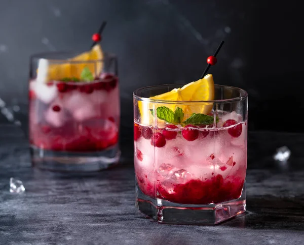 Tranbär cocktail med is, mynta och citron på en mörk bakgrund — Stockfoto