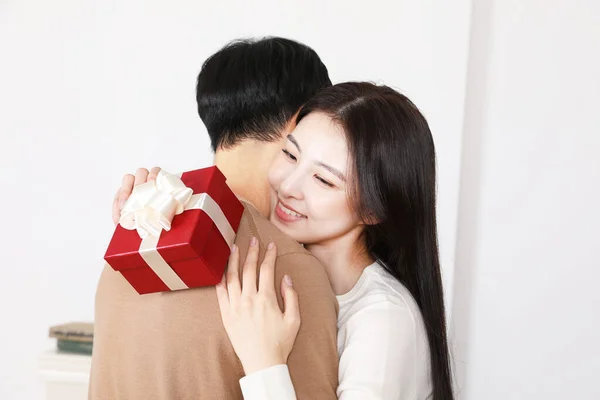 贈り物 ホリデーシーズン ショッピングのコンセプトを交換した後 お互いに抱き合っているアジアの韓国のカップル — ストック写真