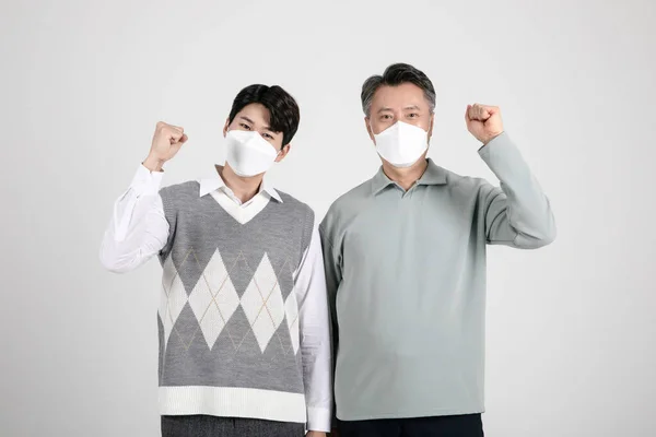アジア系韓国人の老人と若い2人の男性が動きのある仮面をつけて — ストック写真