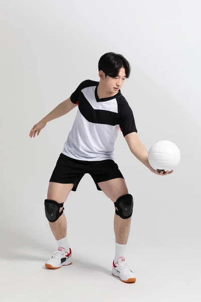 バレーボールのスポーツ選手アジア系韓国人男性が奉仕を準備しボールを出し — ストック写真