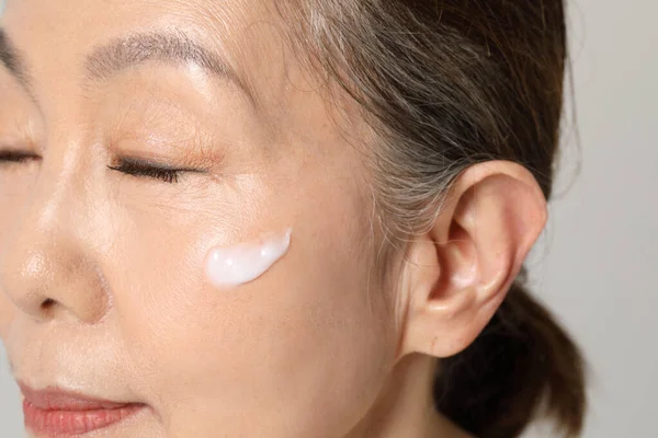 Asian Korean senior woman, basic skin care beauty concept in studio