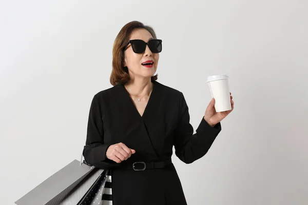 커피와 쇼핑백을 유행하는 아시아의 나이든 — 스톡 사진