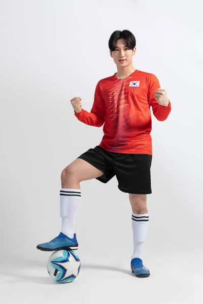 サッカーのスポーツ選手アジア系韓国人男性スタジオの背景に動きがある — ストック写真