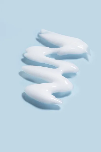Izolowane Rozmaz Kosmetyki Kosmetyczne Tekstury Oczyszczające Mleko Niebieskim Tle — Zdjęcie stockowe