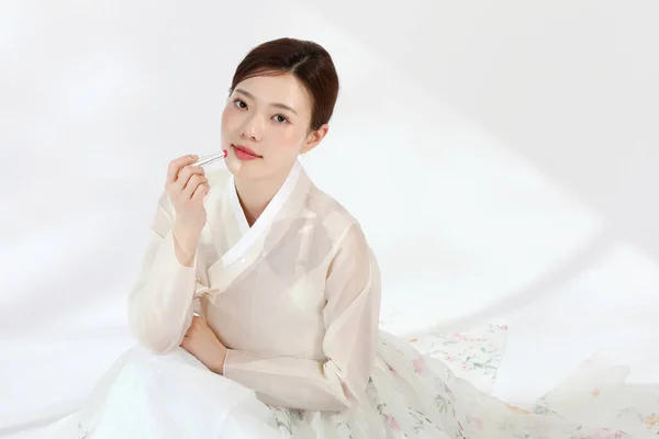 在演播室里穿着韩国话传统服装 手持鲜花 美感的亚裔韩裔年轻女子 — 图库照片