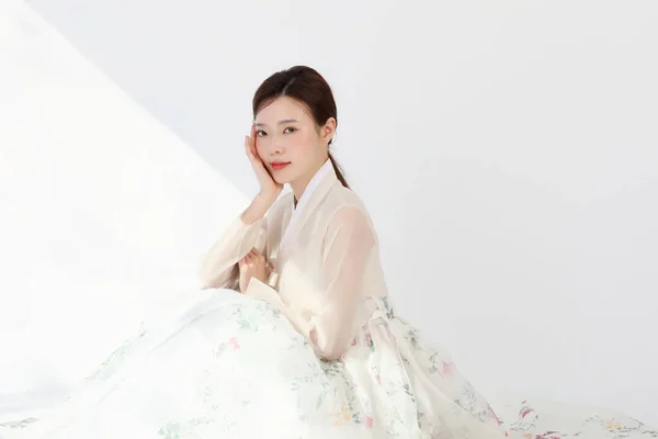 在演播室里穿着韩国话传统服装 手持鲜花 美感的亚裔韩裔年轻女子 — 图库照片
