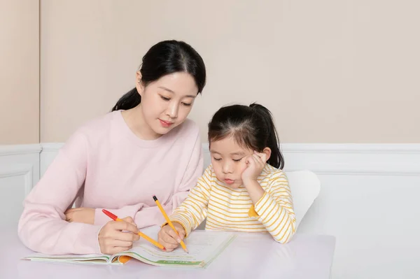 Asian Korean daughter studying with mom